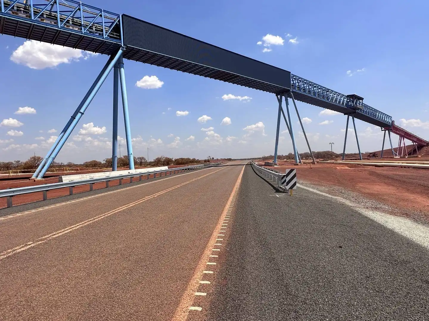 Overland conveyor crossing a sealed haul road at Roy Hill, Pilbara